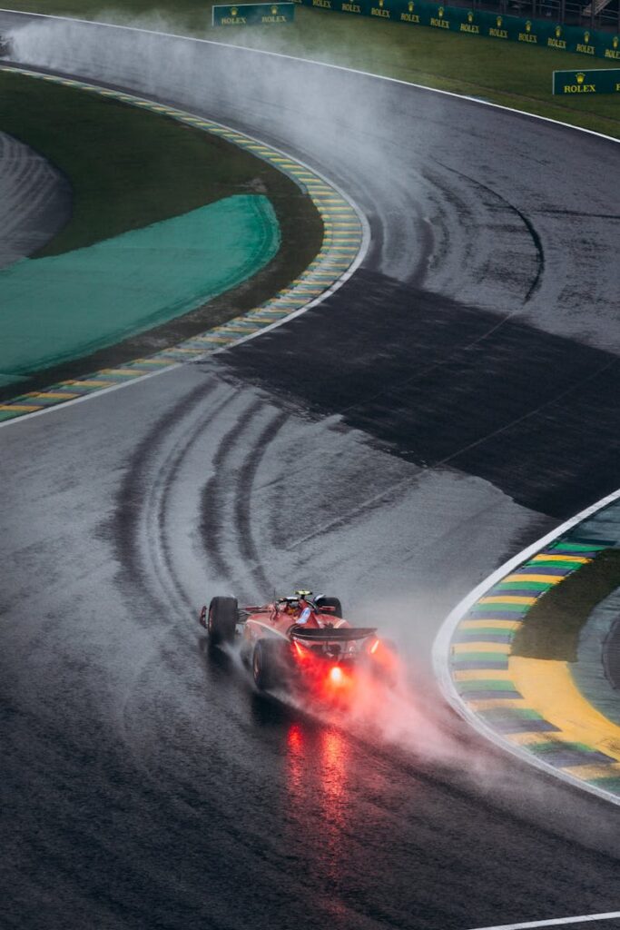 A Ferrari F1 car navigates a wet track during a rainy race in Interlagos, Brazil.